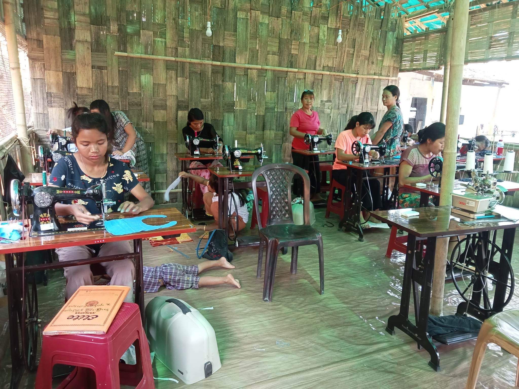 Women at sewing machines in a community workshop, Mizoram