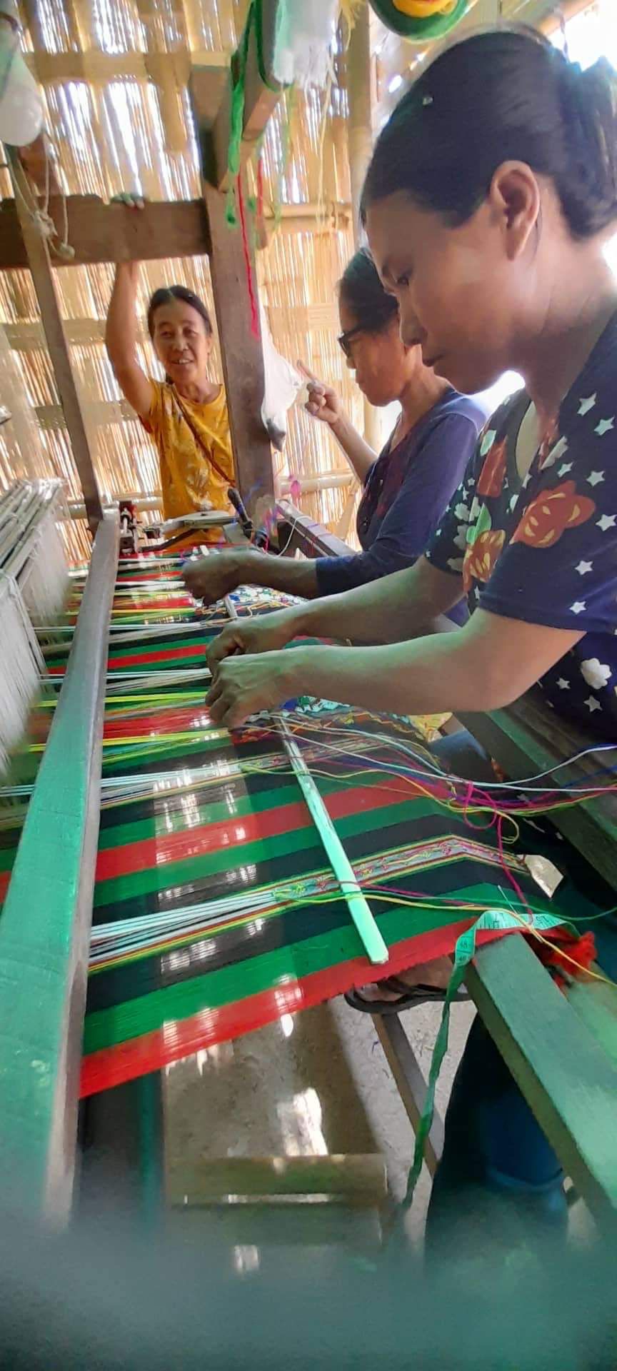 Women weaving traditional fabric on a loom, Mizoram